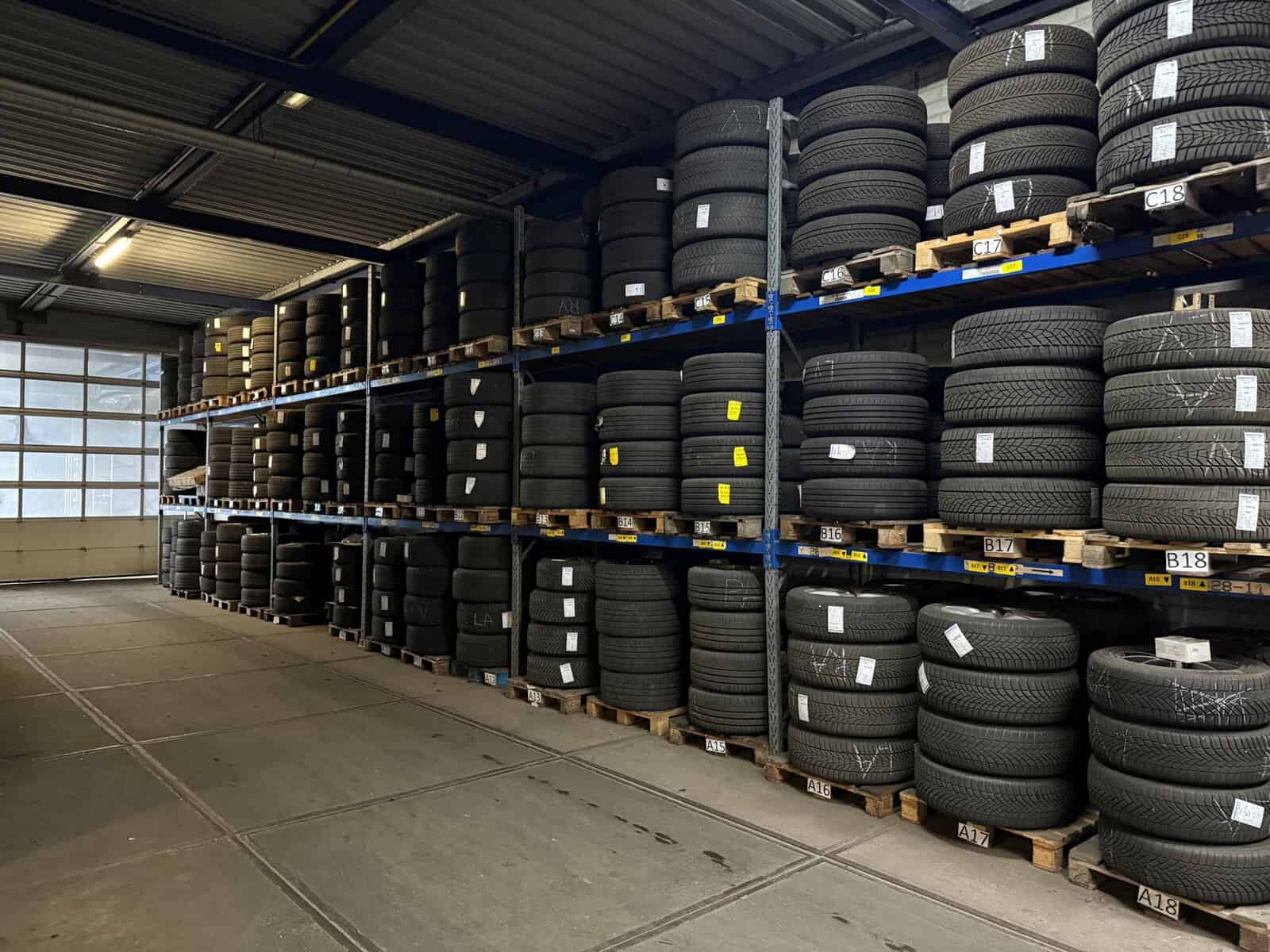 Uitgestalde banden op pallets in een magazijn bij Donkers VAG.